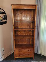 Front view of the wood cabinet showing 4 shelves and 2 drawers closed.