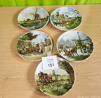 Top view photo showing all 5 handpainted scenic plates with Dutch themes arranged on a wooden surface
