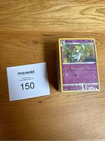 Front view of sealed pack of Pokémon cards with Kirlia card visible and Maxsold identification card