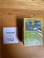 Front view of bundle of over 50 sealed Pokémon cards with Sunflora card visible on top showing HP 90 and move Bright Beam.