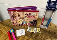 Photo of American Girl Doll Star book, Disney cruise coloring placemat set in box, three Pez dispensers, and two Snoopy dog tag packs on wooden table.