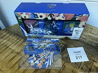 Boxed Disney 70th Anniversary vase set with vases visible through window, next to Disney Marathon Weekend car magnet and auction tag
