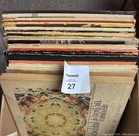 Top view of a row of vintage vinyl record albums showing signs of wear, with a label in the middle.