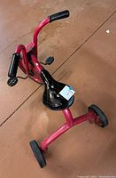 Top angle view of the red vintage kids tricycle showing black seat, pedals and handlebar grips
