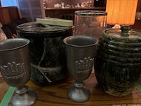 Wide view of all items including pottery ginger jar, marbled ice bucket, clear ice bucket, and two metal corkscrew glasses.