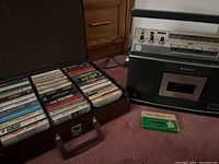 Sony cassette player and open carrying case showing organized cassette tape collection