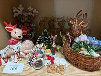 Wide view of Christmas lot with various reindeer decorations and wicker planter with holiday items