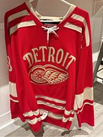 Red front of jersey with Detroit wordmark and winged wheel logo