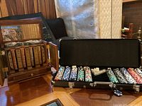 Overview of walnut-finish Franklin Mint cabinet open next to black aluminum poker chip case