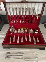 Full view of the open wooden box with silverware laid out inside slots