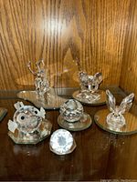 Display of all six items on mirrored bases under wooden shelf