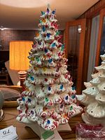 Full front view of the vintage ceramic Christmas tree with multicolored bulbs, showing the white ceramic with red paint accents and the bulbs inserted.