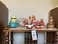 Wide shot of various vintage musical collectible figurines and boxes placed on a wooden table.