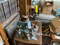 Photo showing multiple eagle figurines on a wooden table including metal and glass pieces