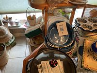 Photo shows two ceramic polka dot baking dishes stacked with packaging material, visible lid knobs with red and black polka dots patterns.
