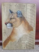 Full view of 3D rustic wall art showing mountain lion head and front leg on wood background.