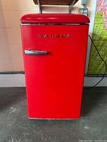 Front view of the vibrant red Galanz mini refrigerator with retro styling and chrome handle.