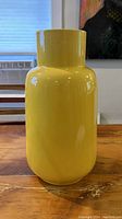 Front view of the large yellow ceramic vase showing its shape and color.