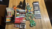 Overview photo showing the entire lot with calculators, staplers, tape, markers, paper clips, and sticky notes on table.