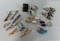 Photo showing the lot contents: six pairs of assorted earrings and eight metal tie clips of various designs and finishes.