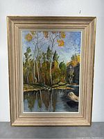 Full view of framed landscape painting showing autumn trees by a pond
