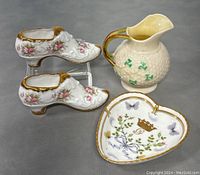 Photo showing Irish Belleek milk pitcher with shamrocks, two Paragon porcelain shoes with floral and gold detailing, and heart-shaped dish with decorative motifs