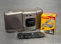 Kodak Advantix C700 film camera with Kodak Black and White 400 film and camera strap on surface.