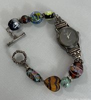 Full view of the ladies wristwatch with the silver bracelet band and colorful glass beads, showing toggle clasp and heart bead detail.