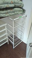 White wire shelving unit standing upright, showing 5 wire shelves from a side angle.