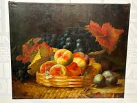 Full view of signed still life oil painting showing fruit basket with peaches, grapes, plums, and autumn leaves against dark background.