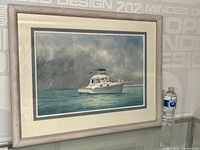 Framed watercolour painting showing full boat and part of frame with a water bottle for scale