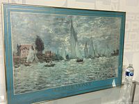 Framed Claude Monet print showing sailboats on water, with matte border and gold frame.