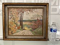 Full view of the framed landscape painting showing trees and a path.