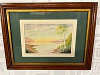 Overall view of the framed painting showing the full seascape artwork including the frame and matting.