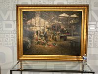 Full view of large framed oil painting showing market scene with vendors inside large industrial building with arched windows.