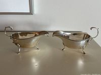 Both sauce boats side by side on flat surface