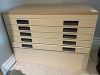 Front view showing six drawers with black recessed handles and wood-grain top