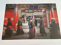 Close-up of the photo print showing multiple people in traditional clothing walking by red gates with detailed decorations, capturing colors and scene details.