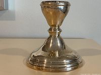 Front view of the polished sterling silver candlestick with visible hallmarks on the base