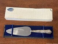 Pie server in original box with white polka dot sleeve and blue velvet interior, top view showing full length and handle engraving