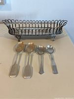 All four spoons laid in front of basket, showing overall grouping