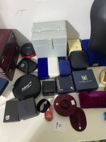 Overview photo showing assorted jewelry boxes, display busts, and small decorative items in various colors including blue, black, white, burgundy, and gray.
