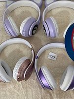 Five wireless headphones laid out on carpet showing cat ear design and various colors