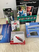 Photo showing multi-project photo paper, Mini Bluetooth speaker, lubricant sheets, USB internet radio, electric stapler, and pack of permanent markers