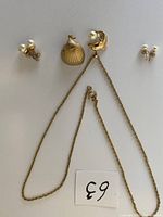 Overview of necklace with dolphin and seashell pendants and two pairs of pearl stud earrings