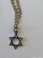 Close-up of the sterling silver Star of David pendant on the chain showing the design and link style.