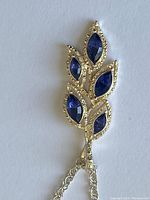 Close-up of the sterling silver pendant with five dark blue marquise-shaped stones arranged in a leaf pattern.