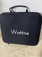 Black zippered carrying case with handle, branded Wattne on front.