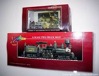 Two boxed items: a large box containing Bachmann Spectrum G scale 36 Ton 2 Truck Shay Ely-Thomas Lumber Co steam locomotive and tender, and a smaller box containing a hand car with trailer and figures.