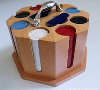 Close-up of the cherry wood poker chip caddy with poker chips in four colors visible (red, white, blue, black) and metal handle on top.